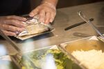 An employee wraps a burrito for an order at a Chipotle Mexican Grill Inc. restaurant in Tempe, Arizona.