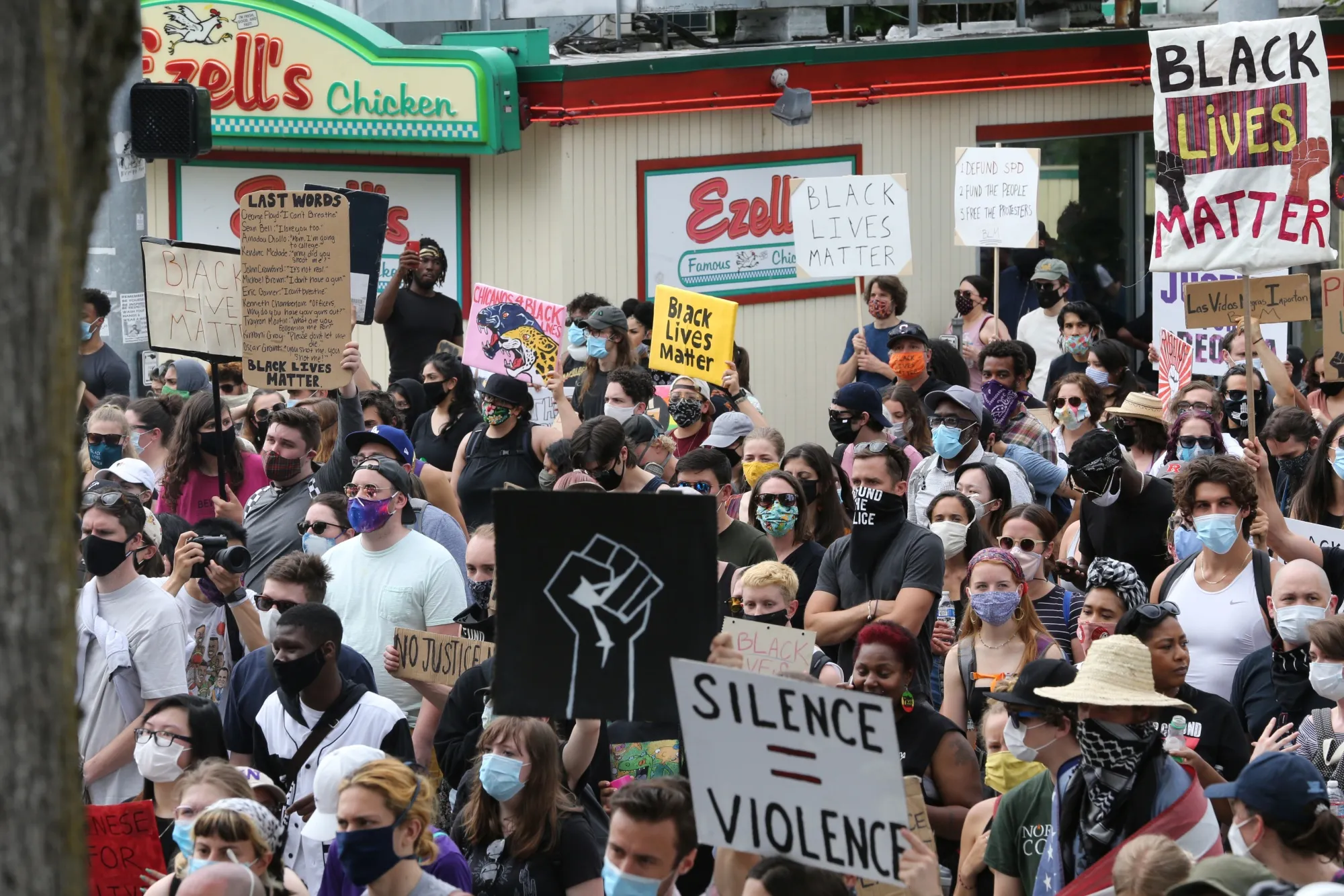 Crowds outside Ezell’s Chicken in Seattle’s Central District neighborhood listen to march organizers explain gentrification issues in this historically black neighborhood during the Juneteenth Freedom March and Celebration on June 19.&nbsp;