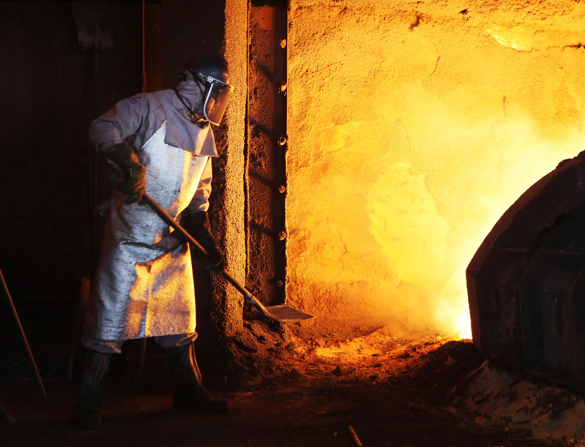 A worker shovels sand into the blast furnace&nbsp;in Serra, Espirito Santo, Brazil.