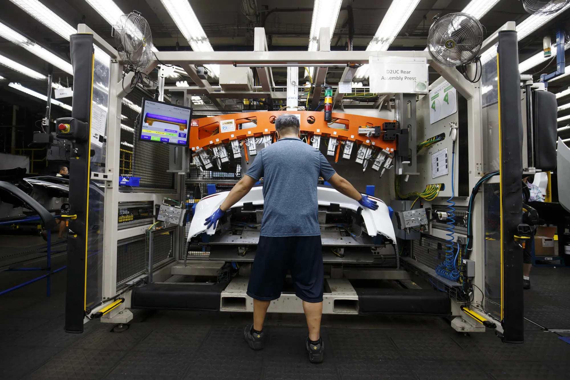 An employee assembles a rear bumper an auto parts manufacturing facility in Guelph, Ontario.