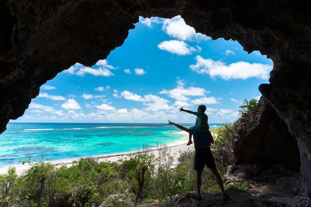 Father and child in sea cave, Two Foot Bay, Barbuda, Caribbean