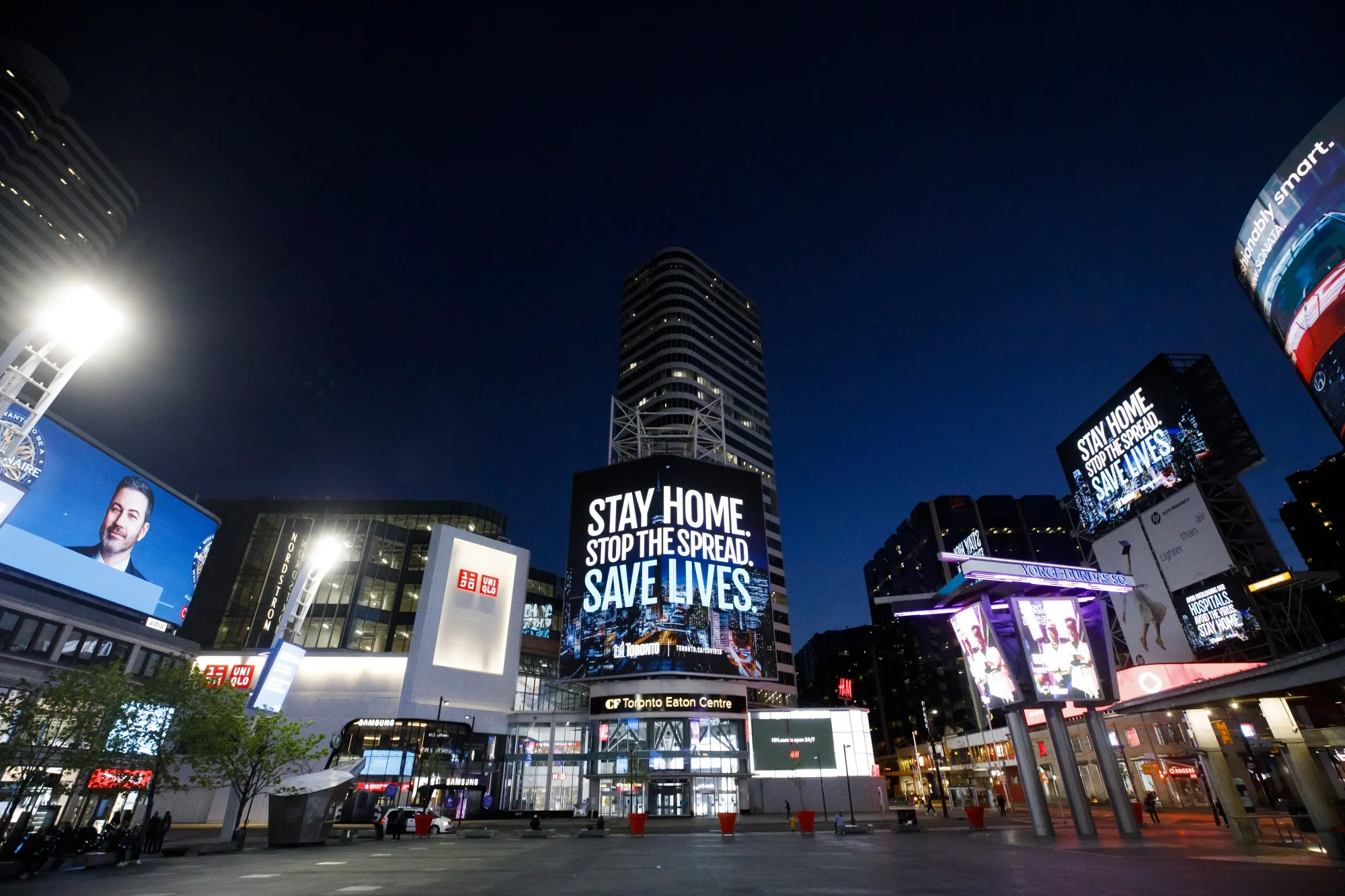 Signs display stay-home orders at Dundas Square in Toronto on May 19, 2020.