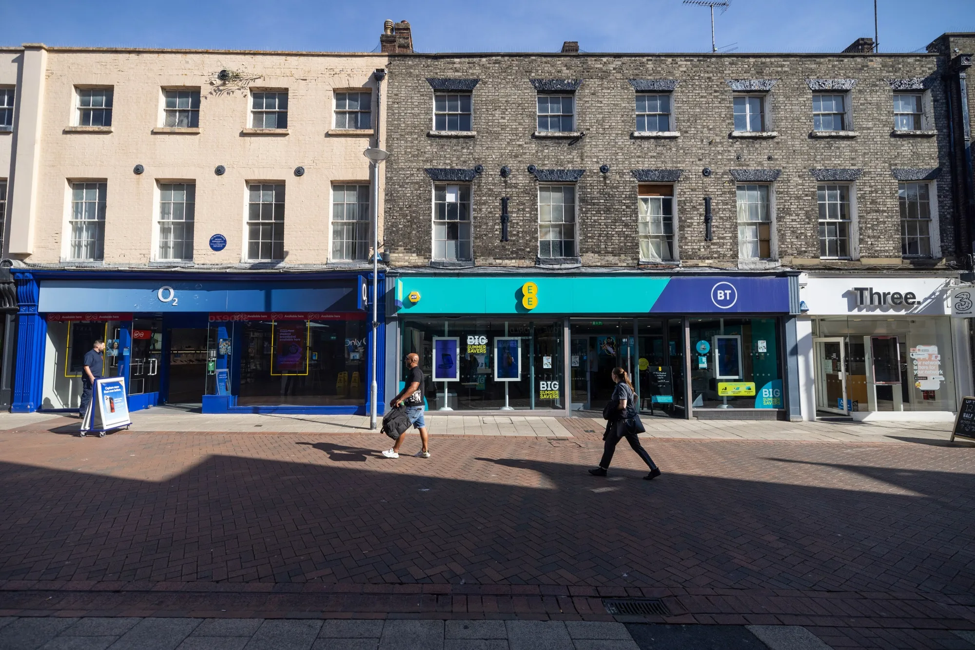 A row of mobile phone stores including O2, EE/BT and Three in Ipswich, UK.
