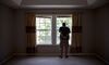 A prospective home buyer looks out the master bedroom window at a house for sale in Dunlap, Illinois.