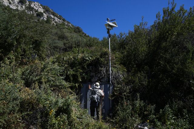 A former forest ranger points to the door of an area where BlueTriton collects spring water in the San Bernardino National Forest.