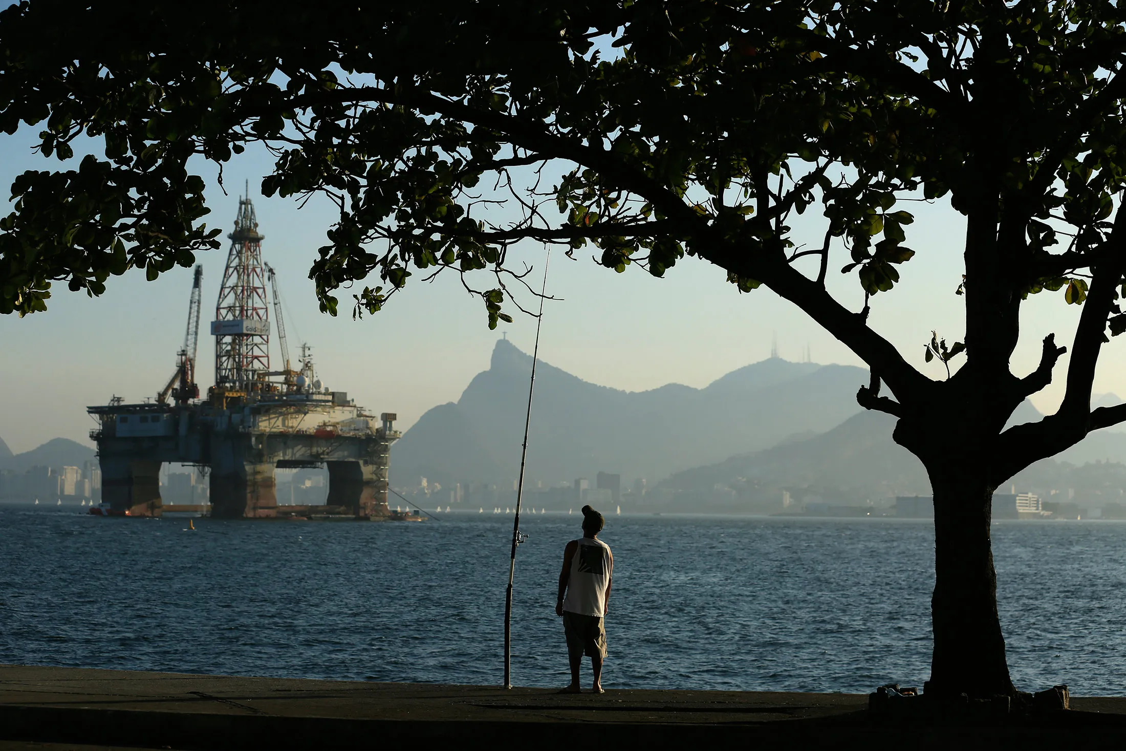 A man fishes in Guanabara Bay while an oil drilling platform floats in the background near Niteroi, Brazil, on April 20.
