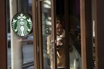A customer exits a a Starbucks Corp. coffee shop with a beverage in New York, U.S..