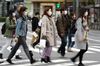 Pedestrians wearing protective masks cross an road in the Ginza area in Tokyo, Japan.