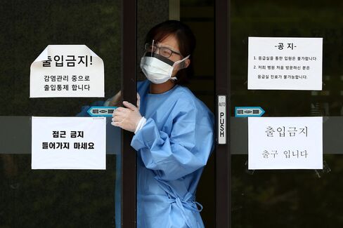 A medical staff employee wearing a mask exits a closed hospital emergency room and restricted area at the Samsung Medical Center in Seoul, South Korea, on Sunday, June 14, 2015. South Korea reported several cases of Middle East respiratory syndrome as the country is shaken by fears of contagion.