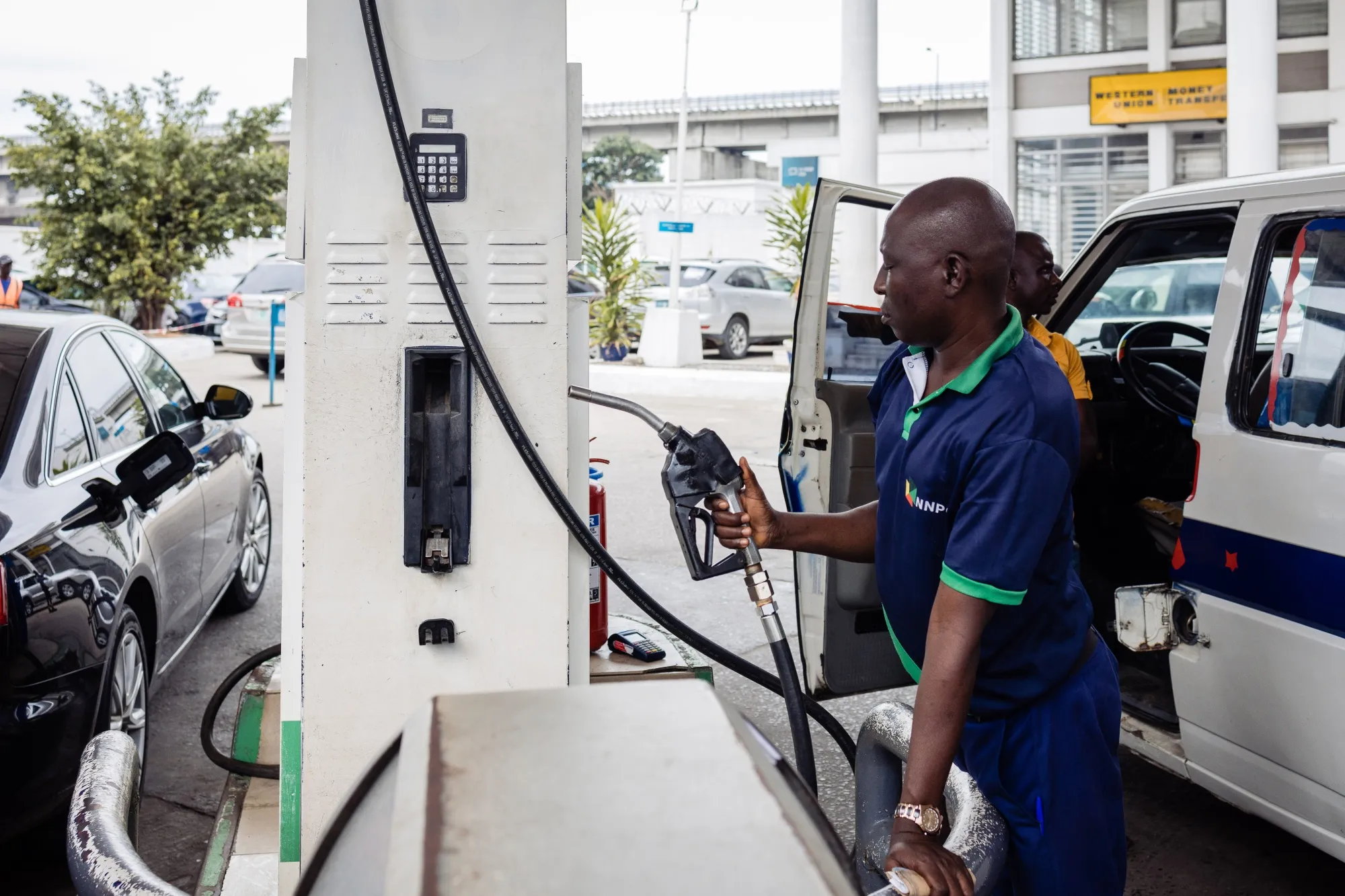 An attendant handles a fuel pump at a&nbsp;gas station in Lagos, Nigeria.