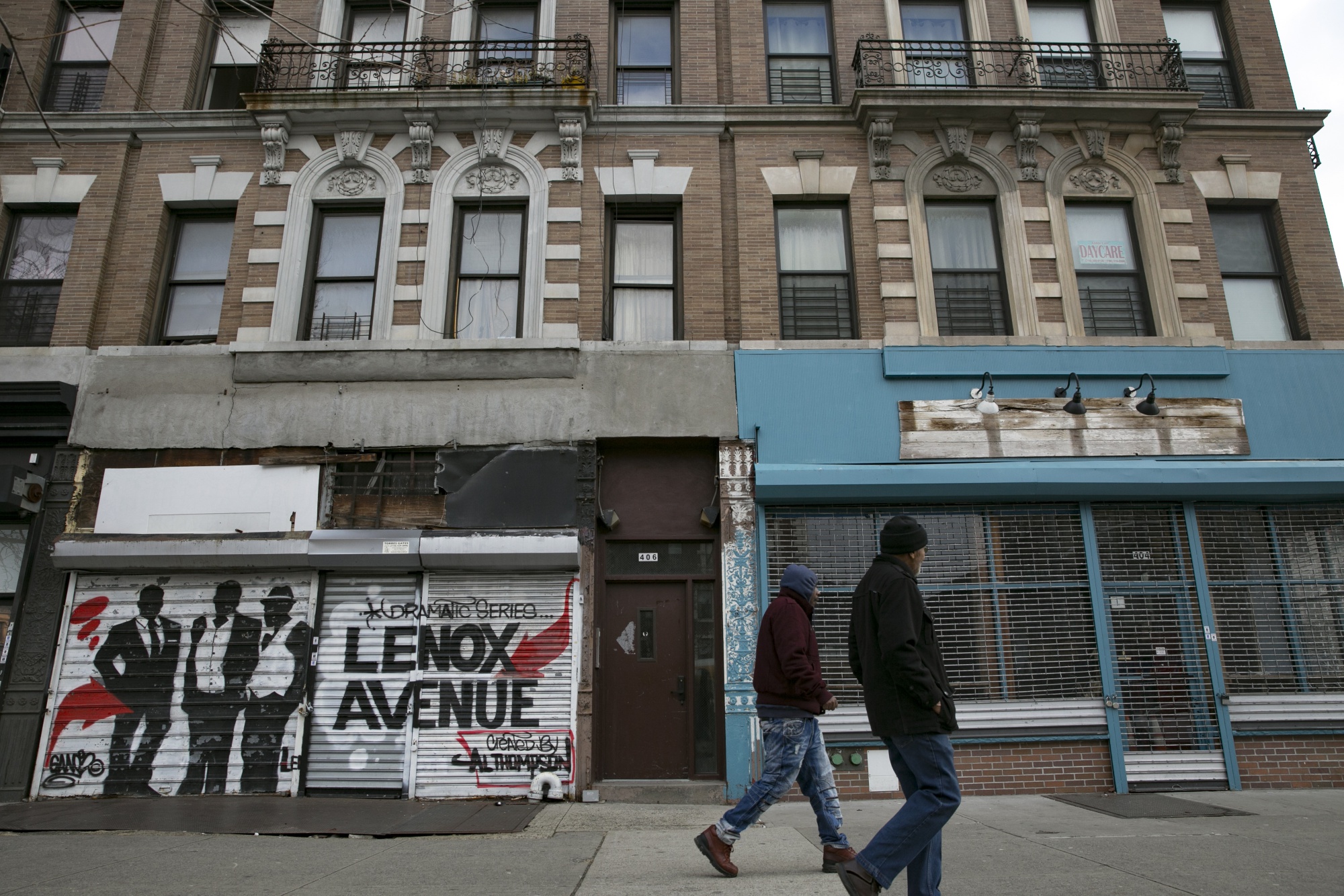 Pedestrians walk past vacant storefronts in the East Harlem neighborhood of New York, U.S.