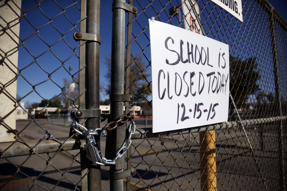 A gate to Birmingham Community Charter High School is locked with a sign stating that school is closed, Tuesday, December 15, 2015, in Van Nuys, California. 