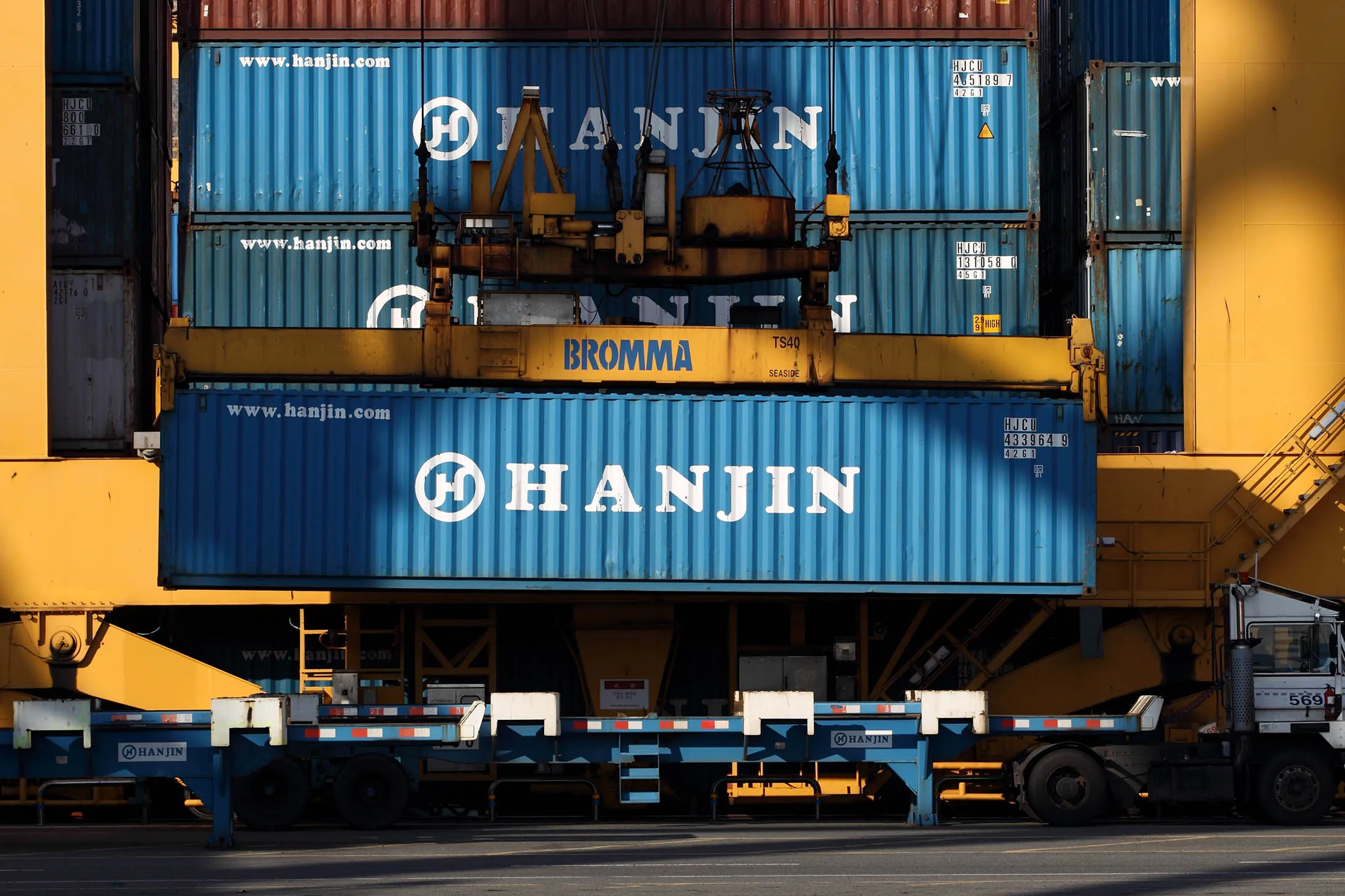 A Hanjin Shipping Co. gantry crane unloads a container from a truck at the company’s Busan New Port terminal in Busan, South Korea, on Tuesday, Dec. 10, 2013.

