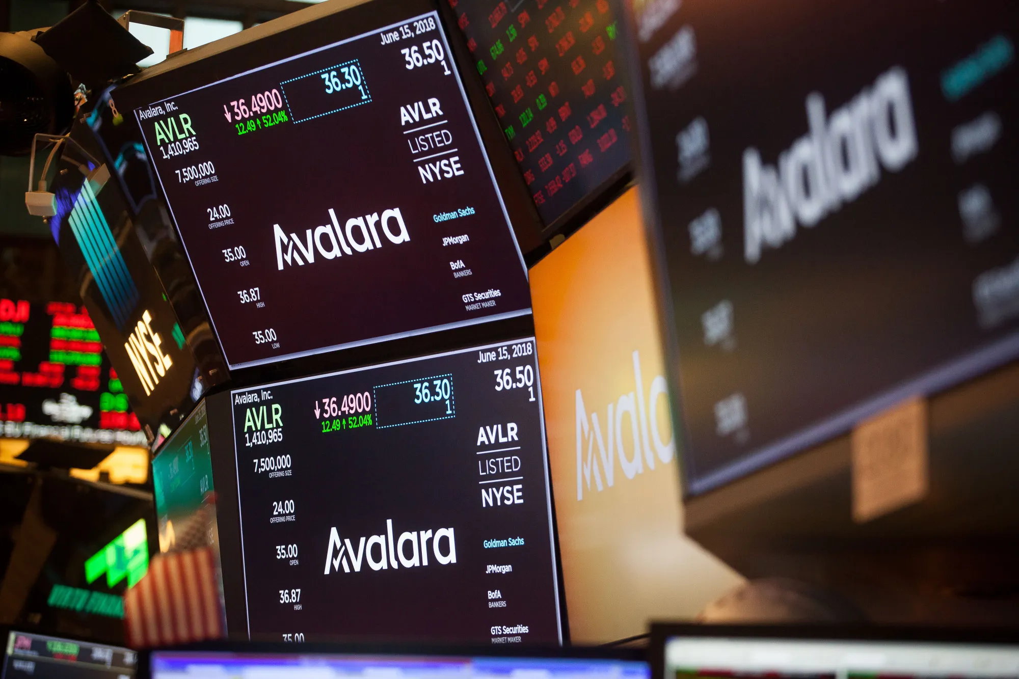 Monitors display Avalara signage on the floor of the New York Stock Exchange.