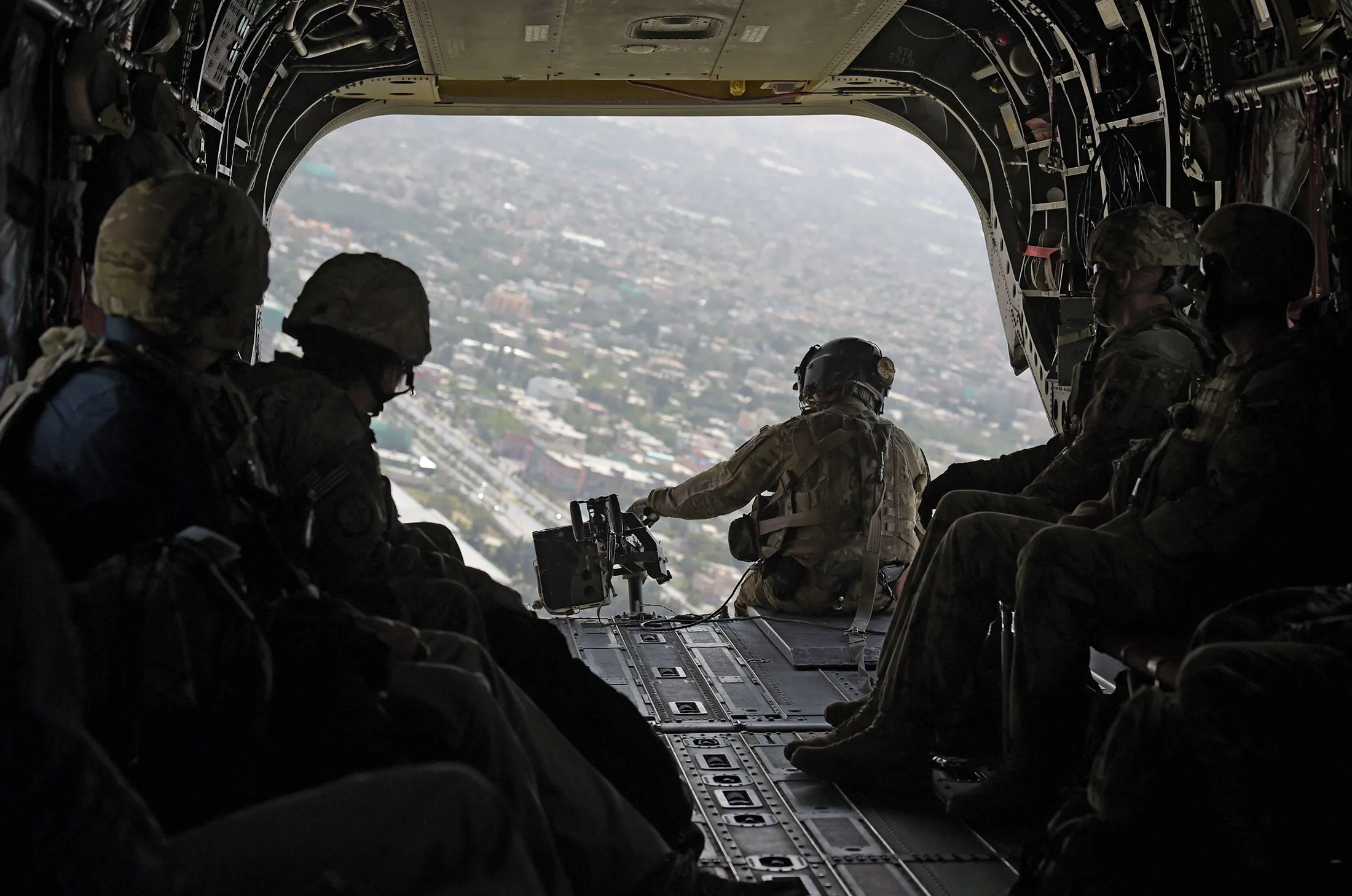 &nbsp;U.S. soldiers sits in the rear of Chinook helicopter while flying over Kabul.