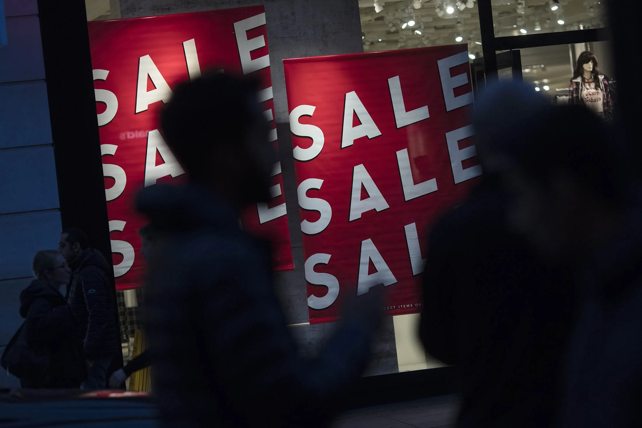 Pedestrians walk past a window display advertising a sale at a Forever 21 Inc. store on Oxford Street in London, U.K.
