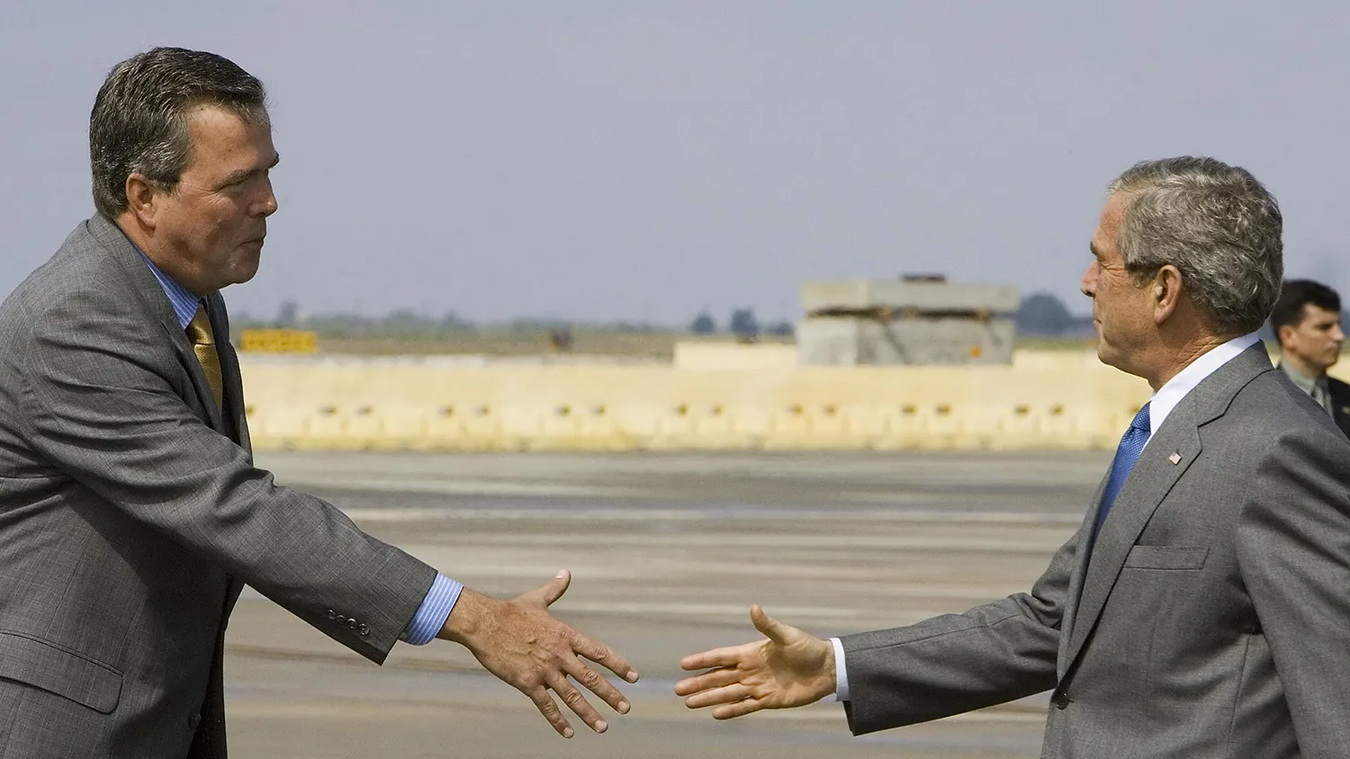 US President George W. Bush (R) reaches out to shake hands with his brother Florida Governor Jeb Bush (L) shortly after Air Force One arrived at MacDill Air Force Base, Florida, 09 May 2006.
