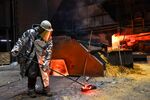 A worker collects a sample of molten steel from a blast furnace at a steel plant in Duisburg, Germany.