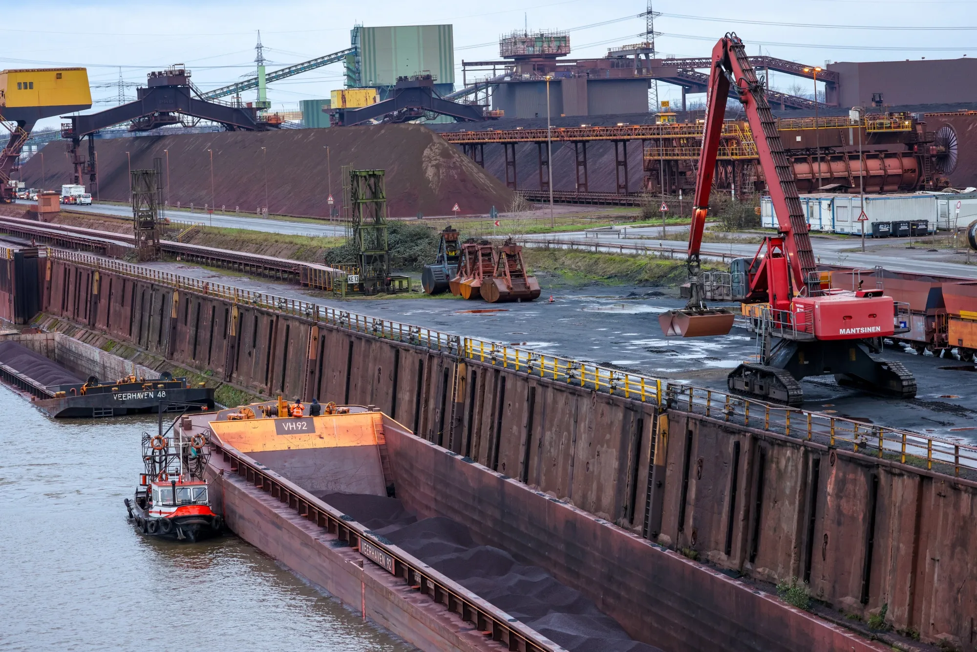 Coal and iron ore barges on the dockside at the Thyssenkrupp Steel Europe AG steel plant in Duisburg, Germany.