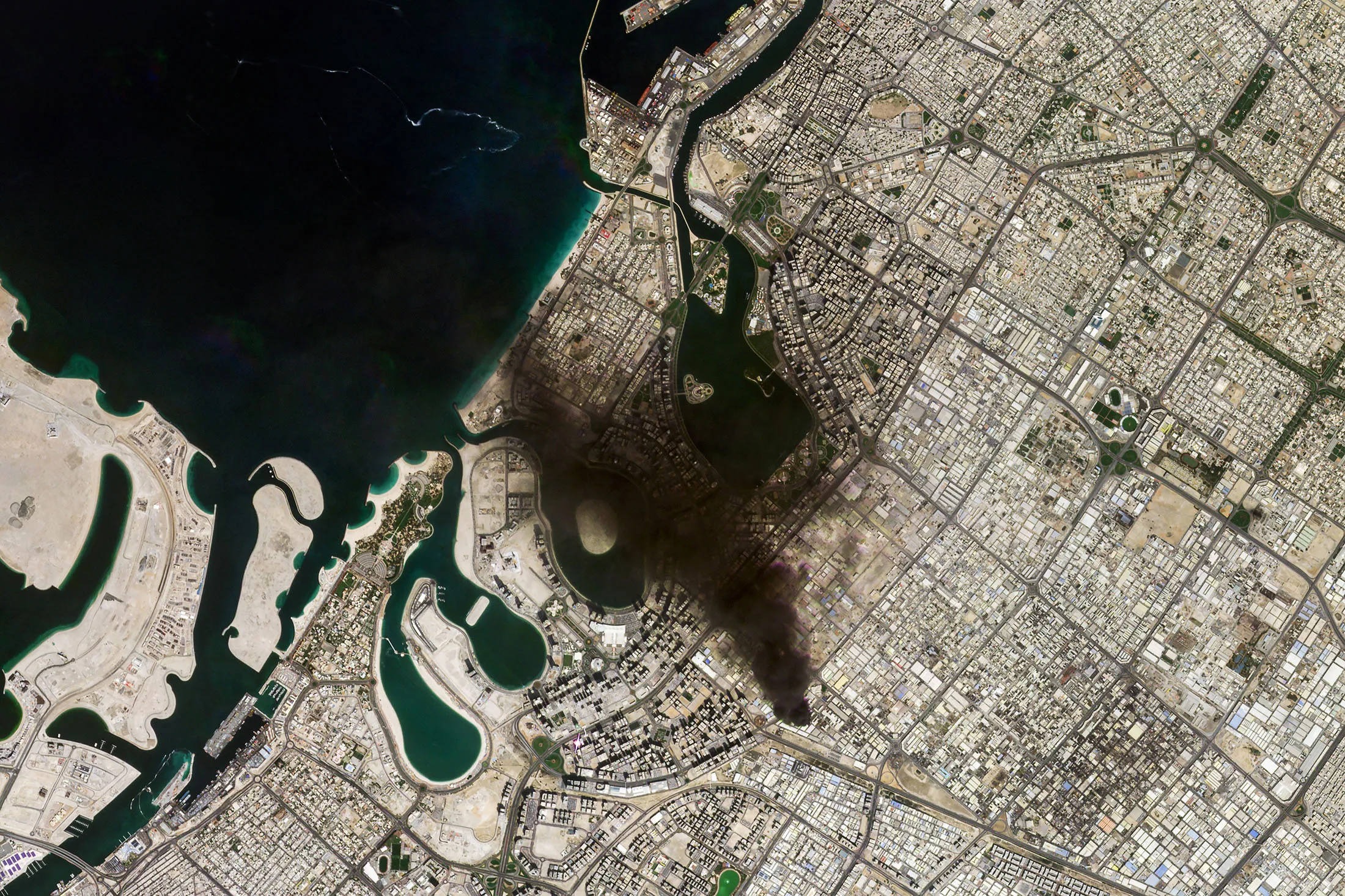 Satellite imagery provided by Planet Labs shows smoke from a fire following Iranian strikes in Sharjah, near Dubai, United Arab Emirates, on March 1.