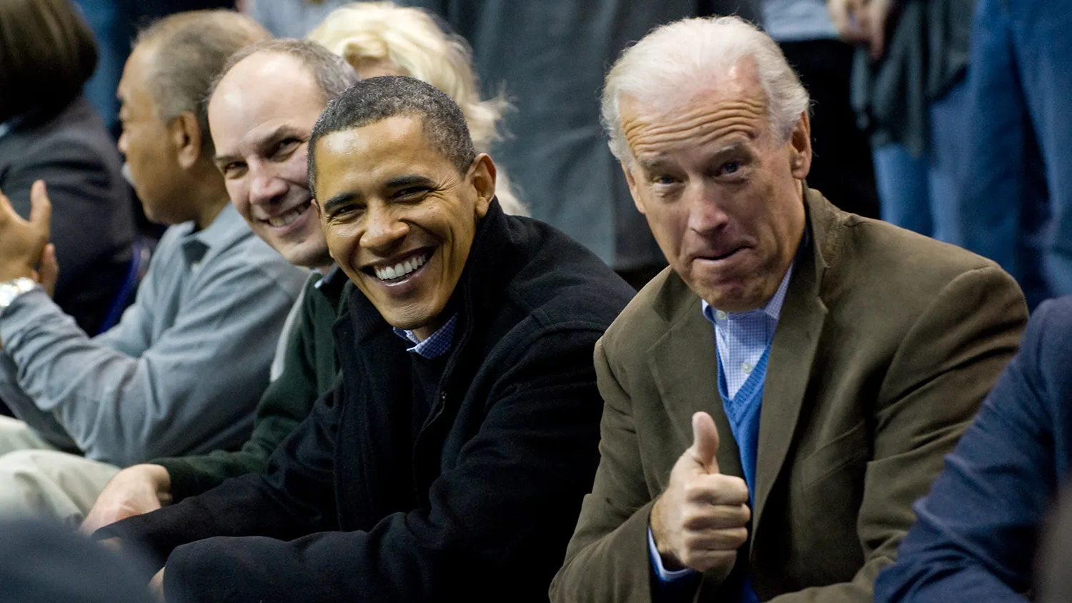 US President Barack Obama sits courtside alongside US Vice President Joe Biden giving a thumbs-up to Georgetown basketball fans during the first half of the NCAA men's college basketball game between Georgetown and Duke at the Verizon Center in Washington on January 30, 2010.
