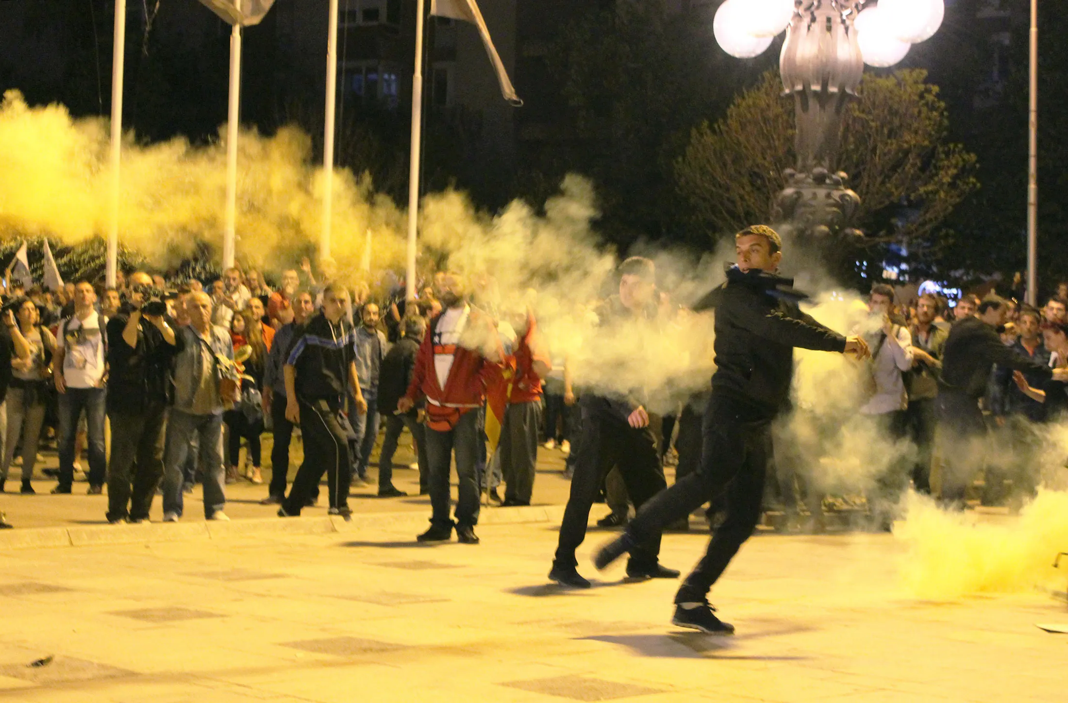 A demonstrator throws a tear gas canister at riot police during a protest demanding the resignation of President Gjorge Ivanov, in Skopje, Macedonia, on April 14, 2016.
