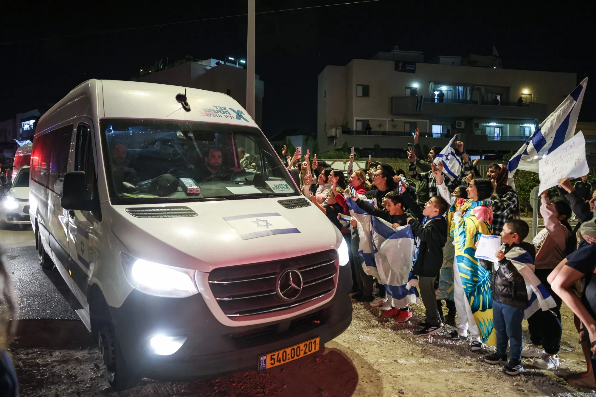 People cheer as a vehicle carrying former hostages&nbsp;drives towards an army base in Ofakim, Israel on Nov. 26.