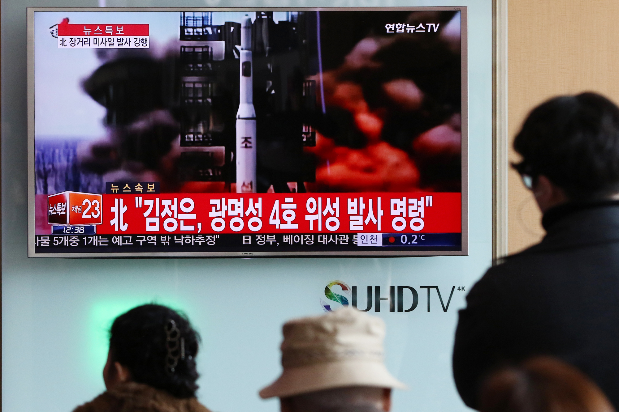 People watch a television screen showing a news broadcast on North Korea's long-range rocket launch at Seoul Station in Seoul, South Korea, on Sunday, Feb. 7, 2016.
