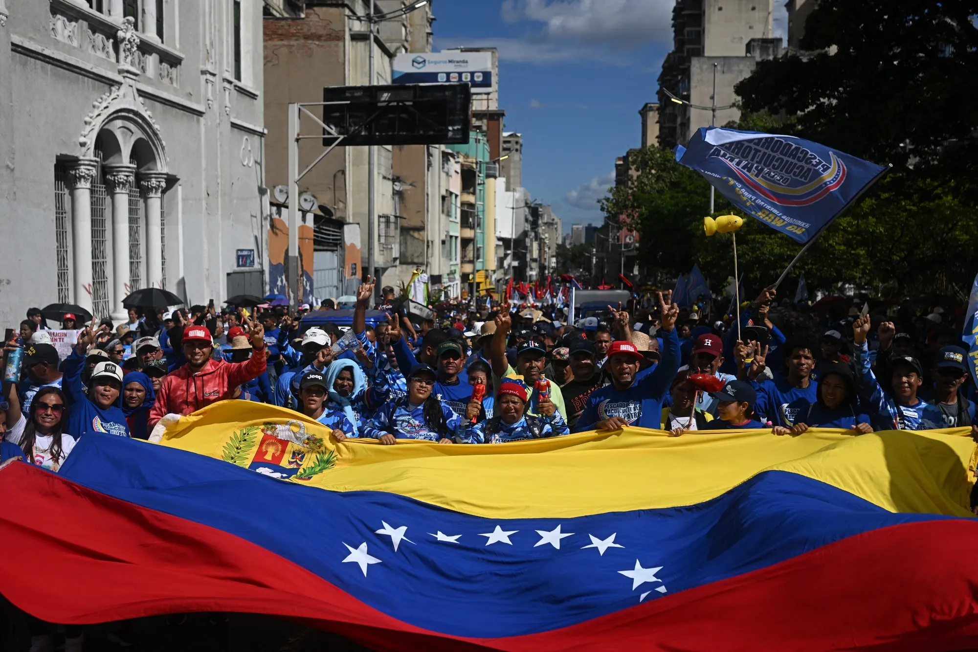 Demonstrators wave a huge Venezuelan flag during a march in Caracas on Jan. 9, 2026, to demand the release of deposed Venezuelan president Nicolas Maduro.