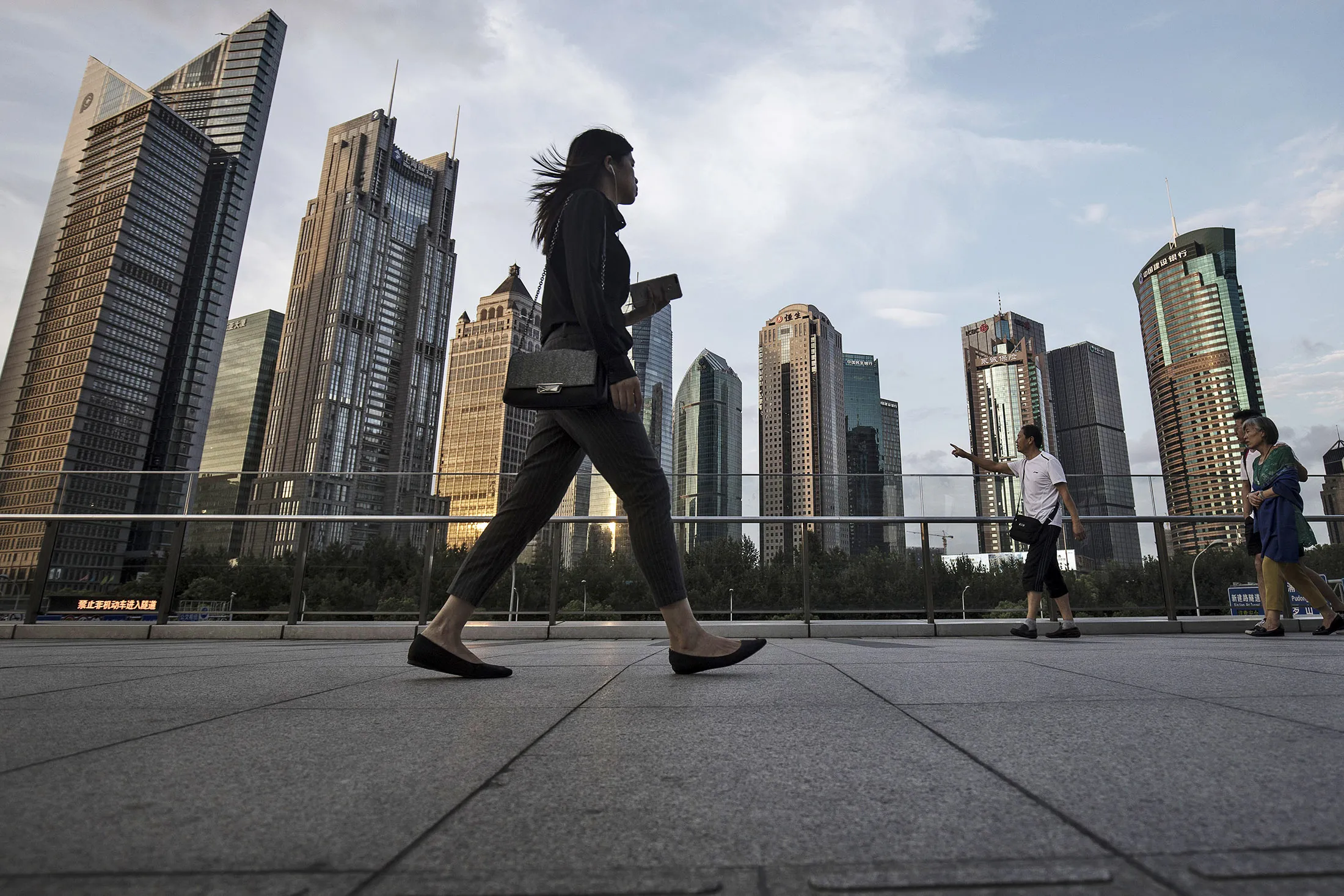 Pedestrians walk along an elevated walkway in the Lujiazui Financial District in Shanghai, China.