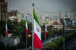 Iranian national flags fly near a major highway through Tehran.