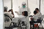 A healthcare worker collects a swab sample at a coronavirus testing site in Jakarta.