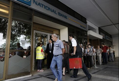 A security guard delivers cash to a bank branch in Athens on July 6