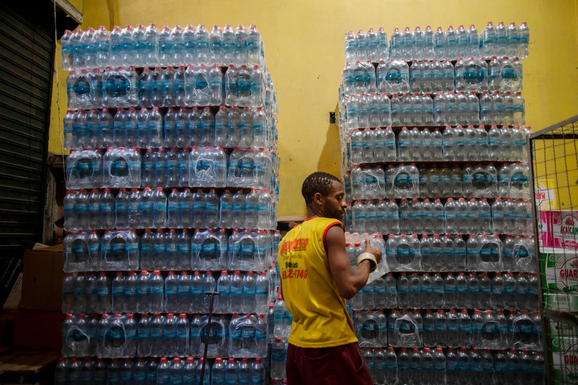 An employee organises packs of bottled water inside a store in Rio de Janeiro.