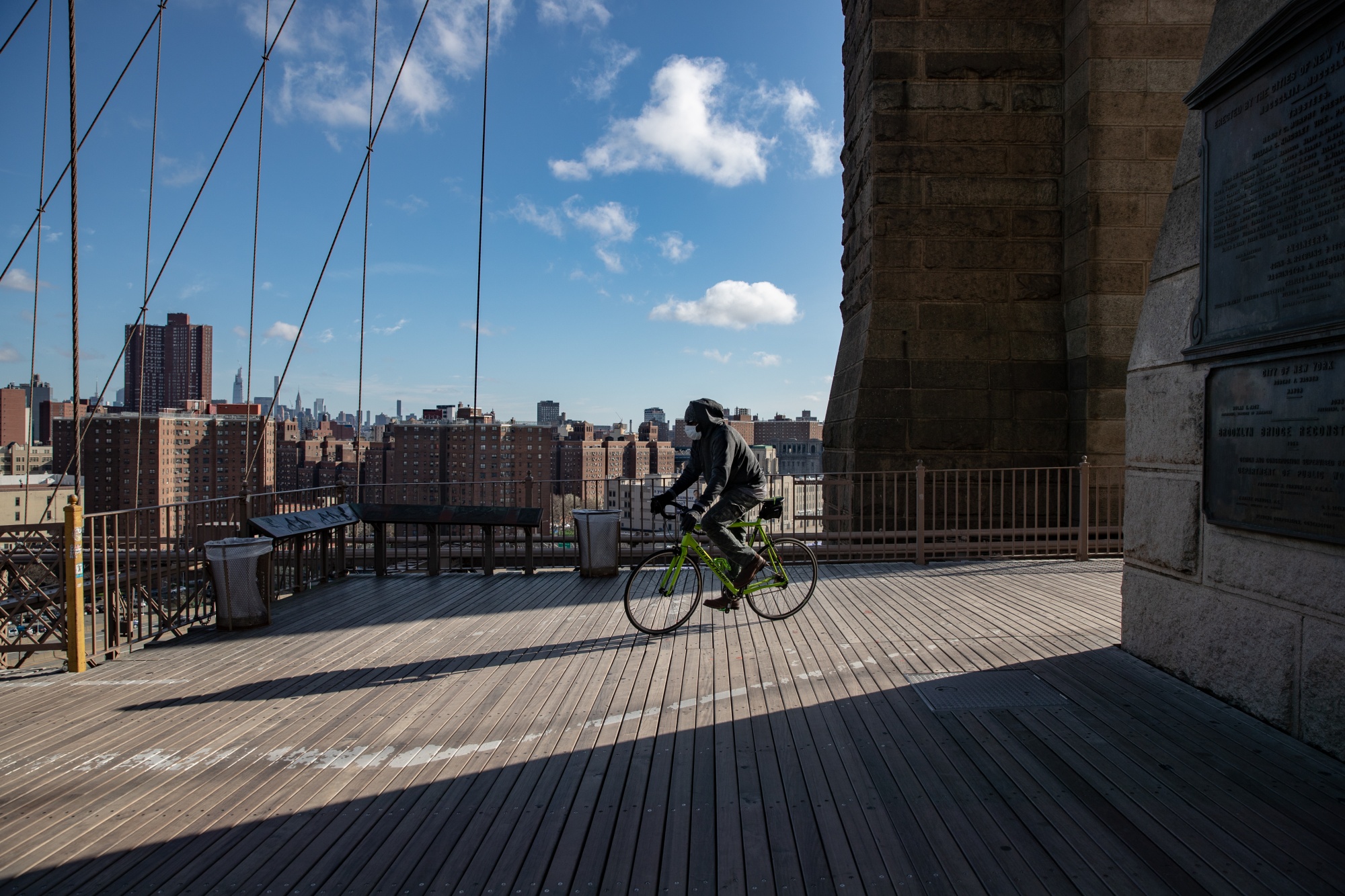 A person rides a bicycle across the Brooklyn Bridge in New York on April 1.
