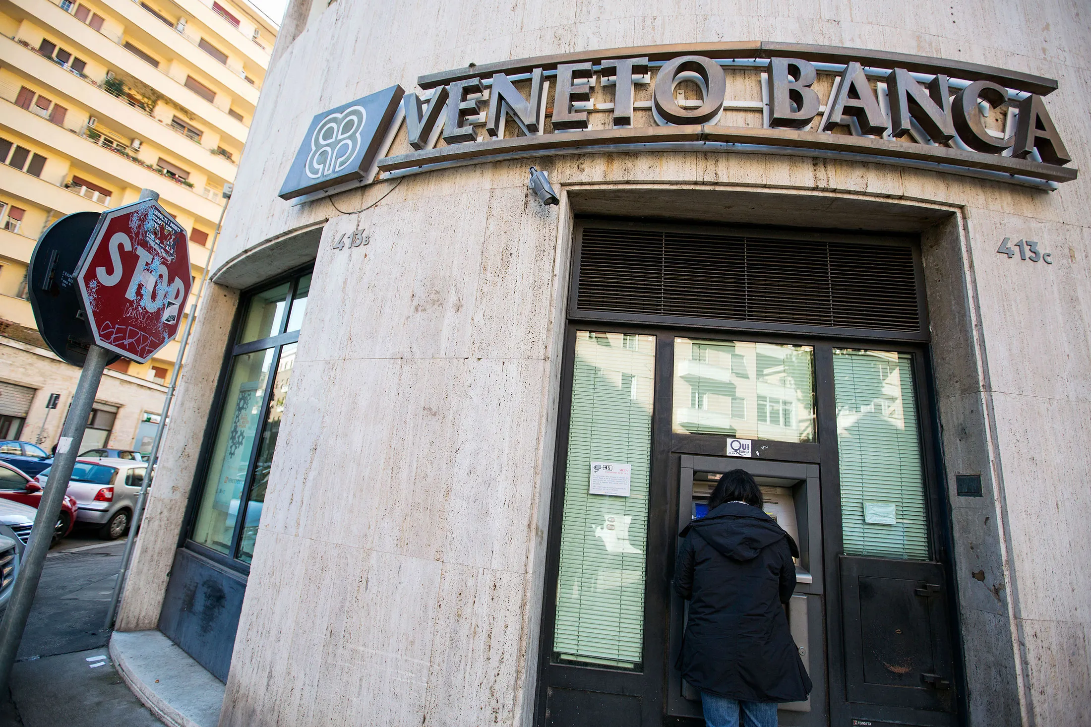 A customer uses an automated teller machine (ATM) at a Veneto Banca SpA bank branch in Rome, Italy.
