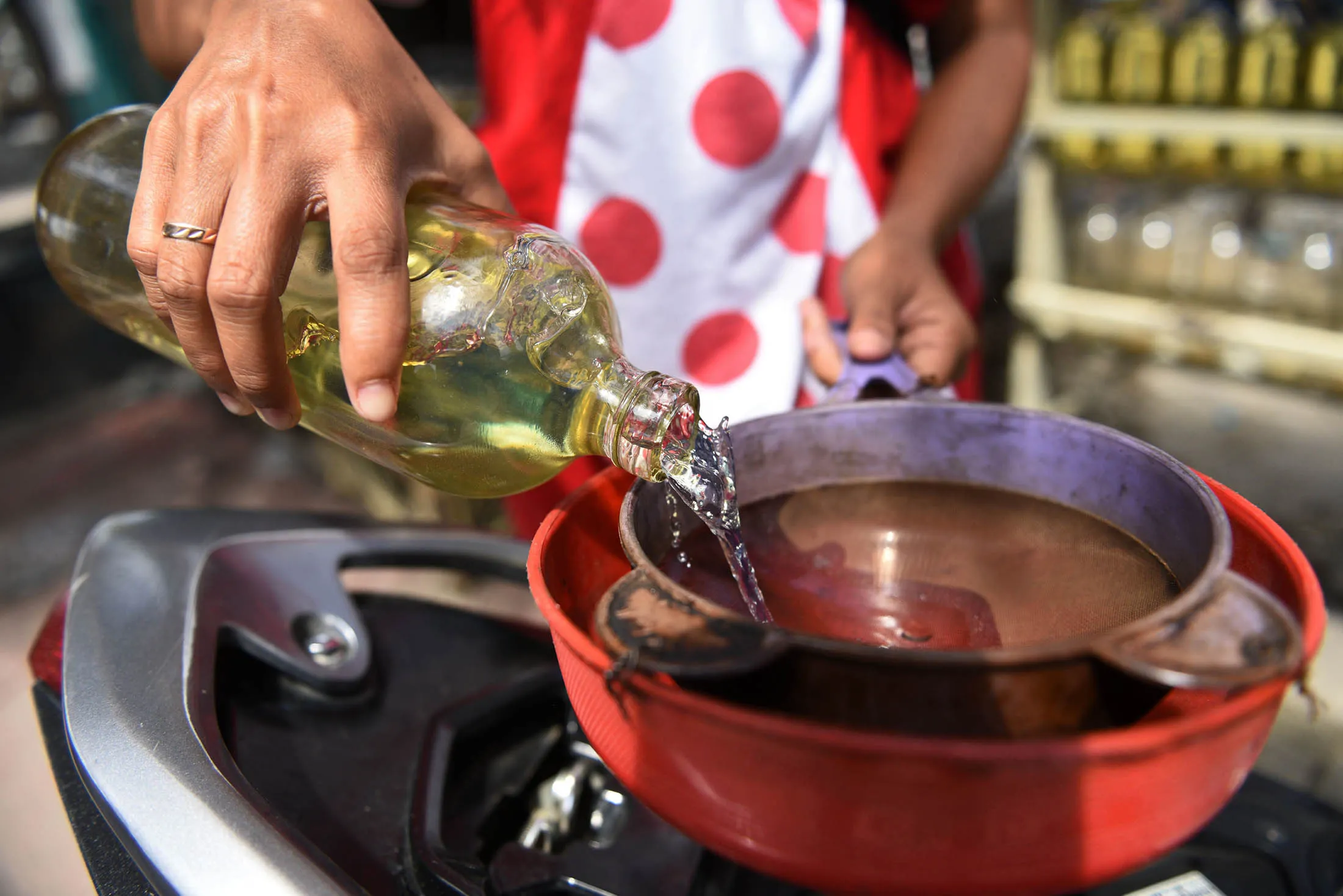 A vendor pours gasoline into a funnel while filling a customer's motorcycle at a street stall in Jakarta, Indonesia, on Wednesday, Jan. 21, 2015. Indonesia will overhaul national oil company PT Pertamina as the government seeks to improve the management of state-owned enterprises and deliver infrastructure projects after slashing fuel subsidies.

