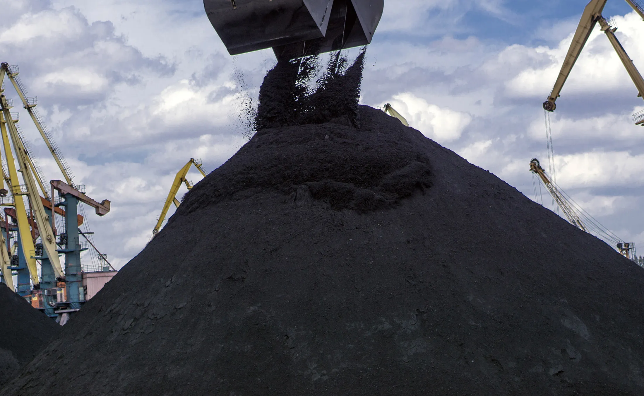 A clam shell crane bucket unloads the first shipment of anthracite coal.