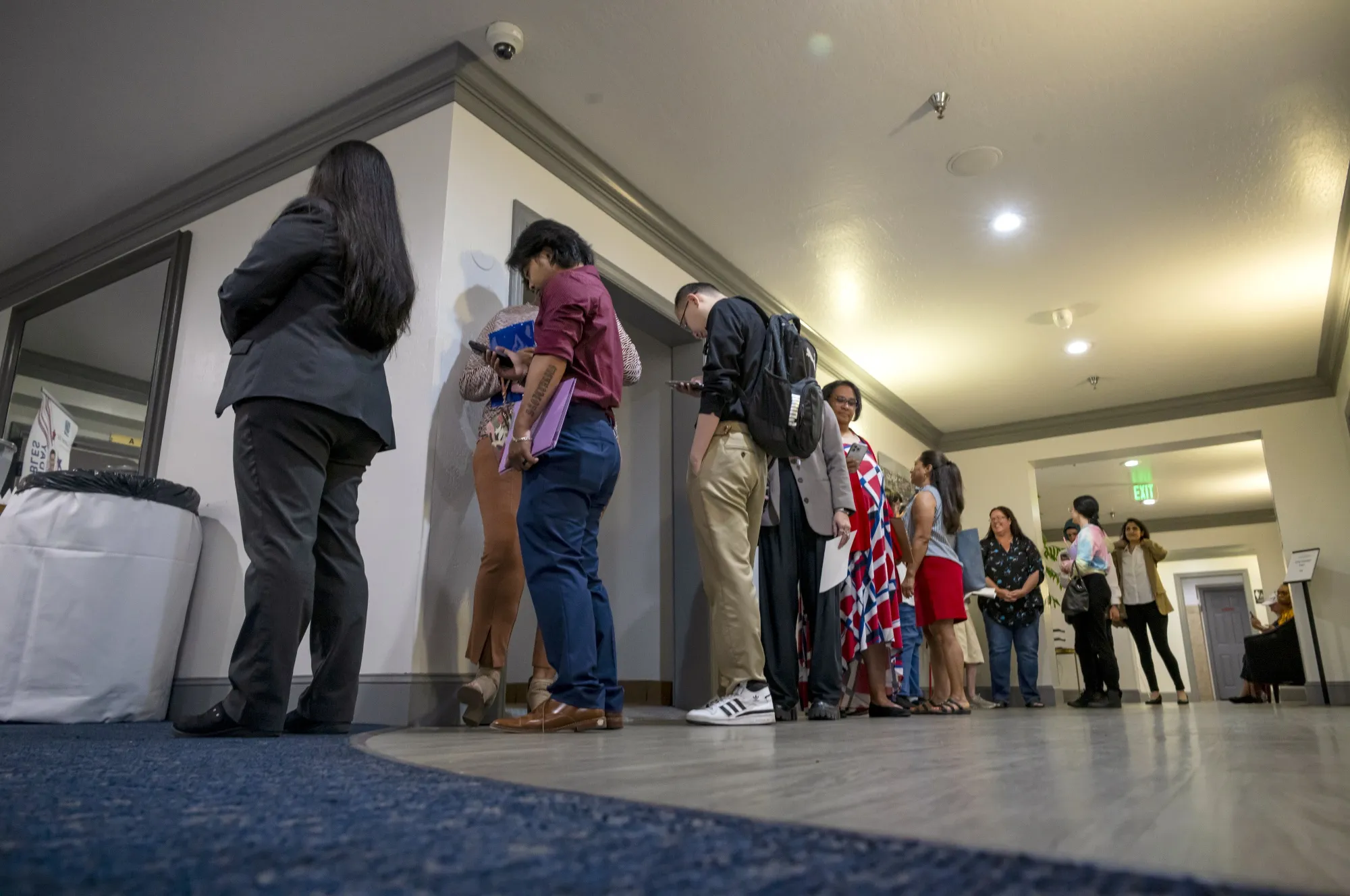 Attendees wait in line to enter the City Career Fair hiring event in Sacramento, California.