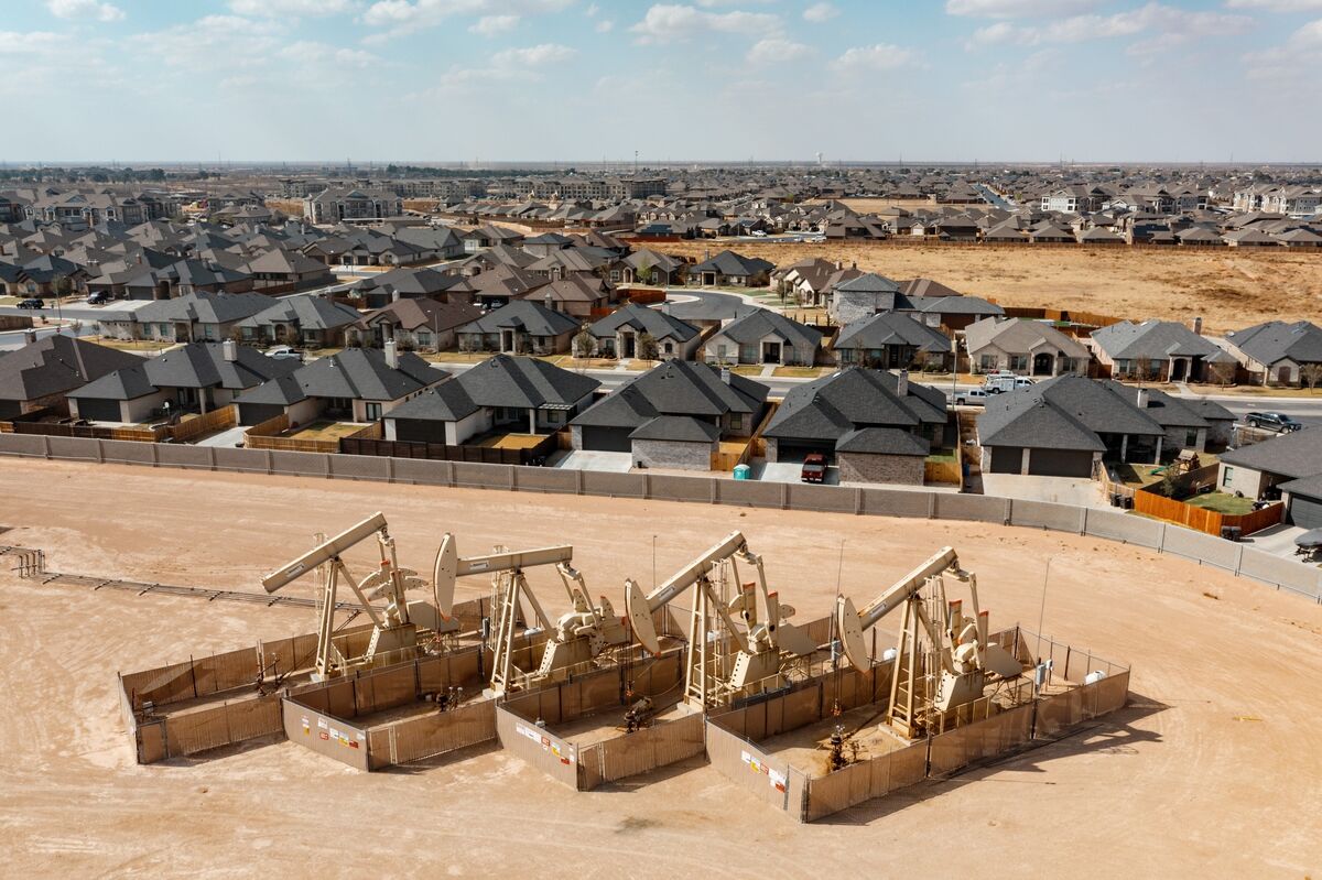 Suburban housing developments adjacent to oil pump jacks in the Permian Basin.