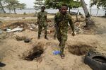 Nigerian naval personnel pass holes dug by vandals to steal oil from pipelines belonging to the Nigerian National Petroleum Company, near Lagos harbour.
