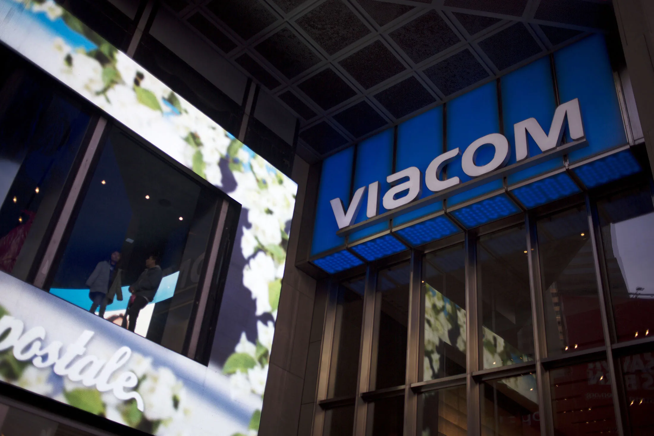 Employees stand in a window next to Viacom Inc. signage at the company's headquarters in the Times Square area of New York, U.S., on Saturday, Feb. 6, 2016. Viacom is scheduled to report earnings figures on February 9.
