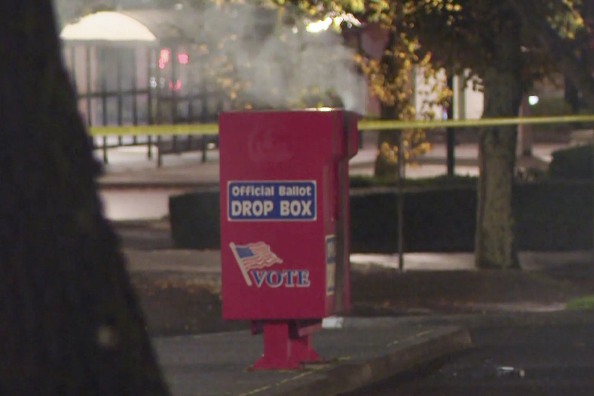 In this image made from a video provided by KGW8, authorities investigate as smoke pours out of a ballot box in Vancouver, Washington, on Oct. 28.&nbsp;