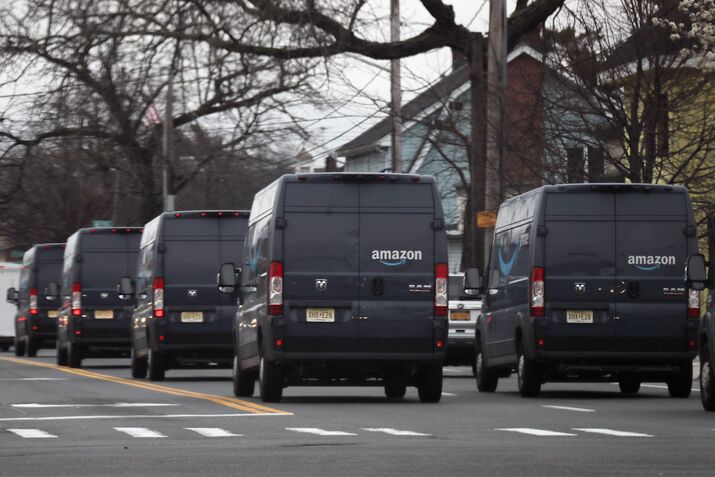 A fleet of Amazon vans take to the streets of Hicksville, New York, in March 2020. The pandemic triggered a boom in e-commerce deliveries, and cities are feeling the effects of freight vehicles on their streets.&nbsp;