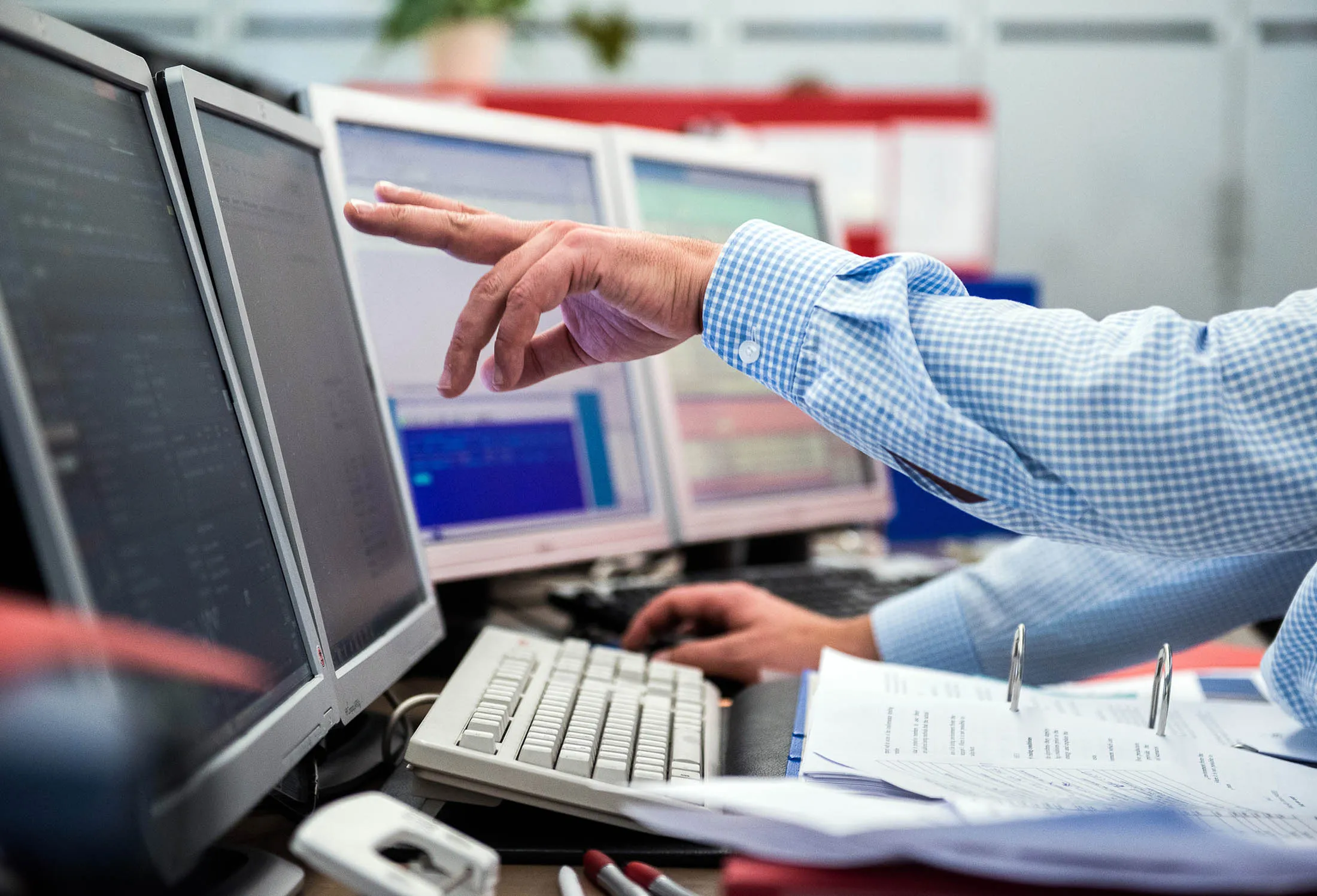 A financial trader points to data displayed on computer screens at the Wiener Boerse AG stock exchange in Vienna, Austria.
