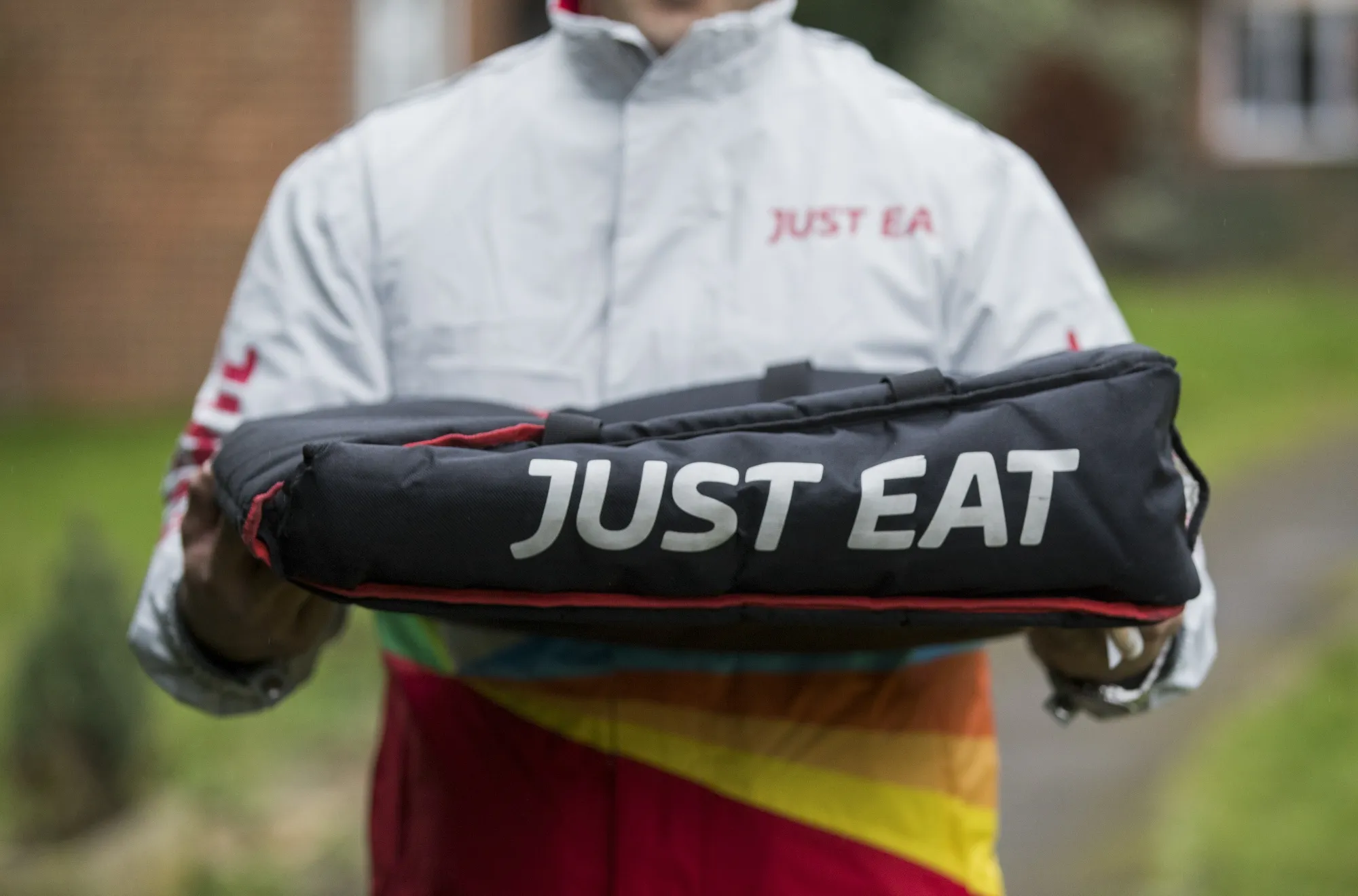 An employee wearing a Just Eat branded coat delivers a pizza in Southend-on-Sea, U.K.