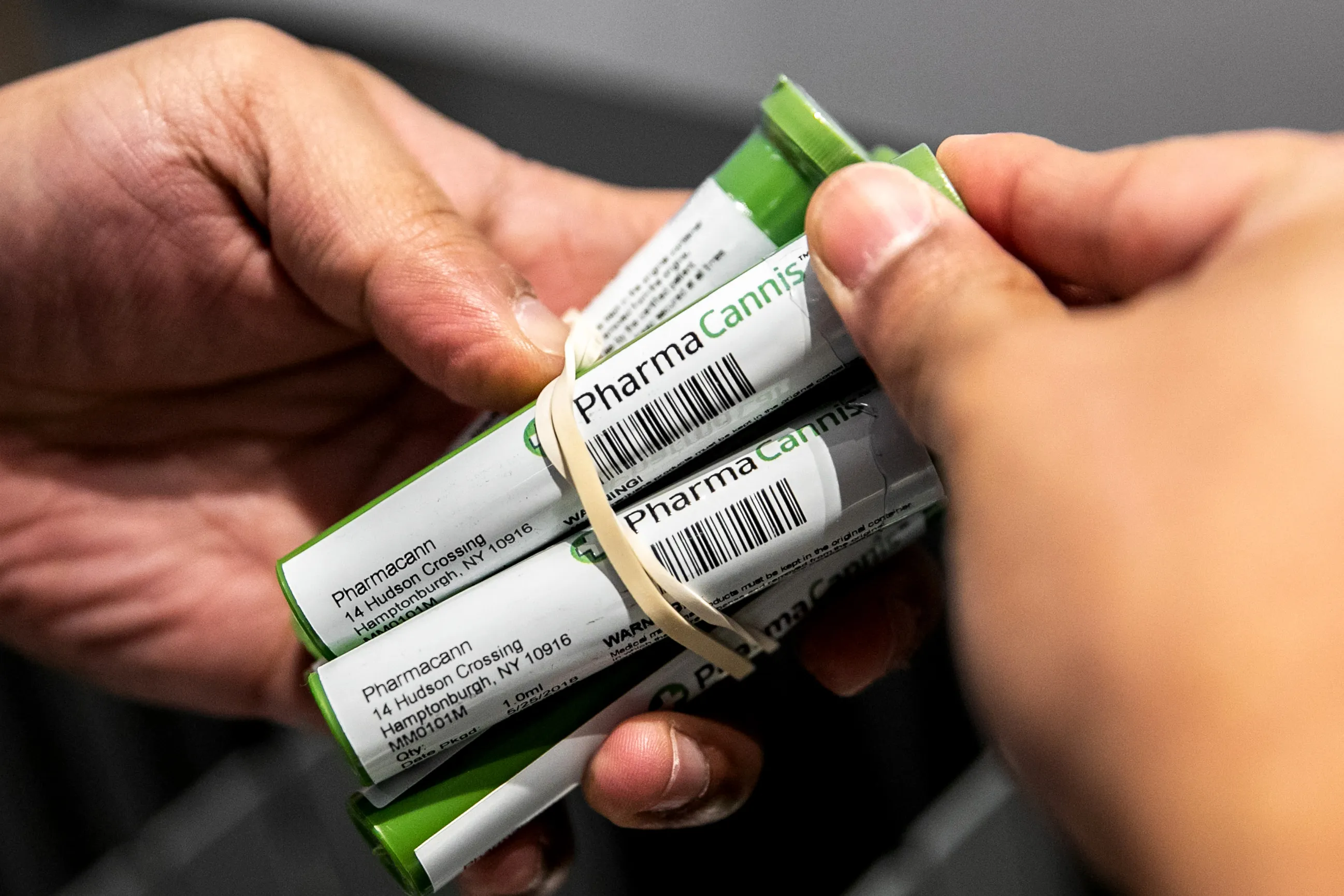 An employee holds PharmaCannis products at a store.