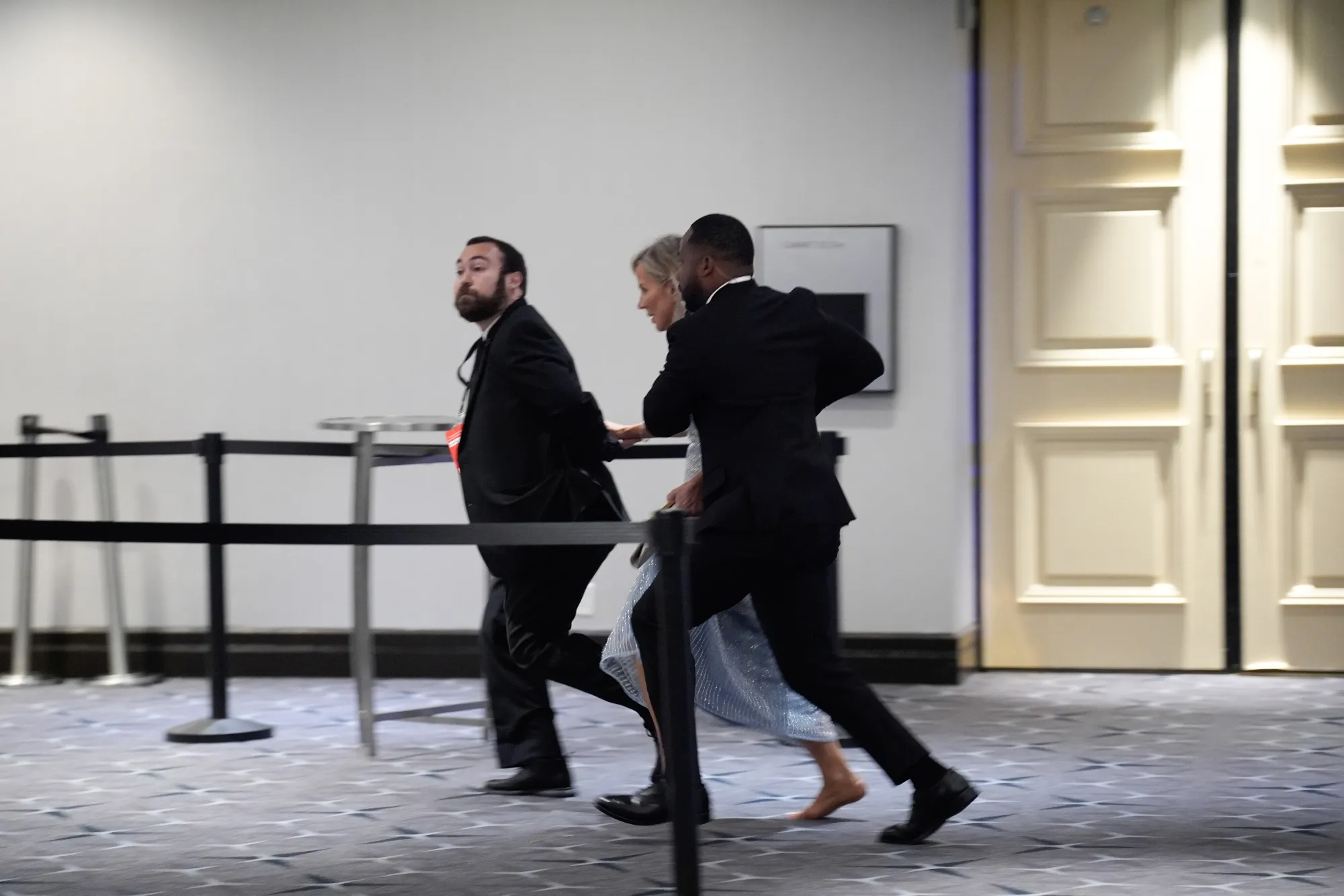 Attendees run following reports of a shooting during the White House Correspondents' Association (WHCA) dinner in Washington, DC, US on Saturday, April 25, 2026. President Donald Trump and Vice President JD Vance were evacuated from the White House Correspondents’ Association dinner event in Washington Saturday following a security incident at the venue.