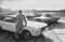 Ford Motor Co President Lee A Iacocca leaning against a F
