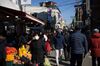 People wearing protective face masks walk through a market in Seoul on Feb. 9. 